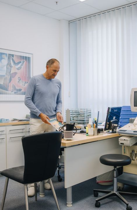 Hausarzt Dr. Doßow bereitet das Behandlungszimmer in seiner Praxis in Magdeburg für Patienten vor.